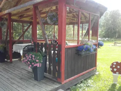 a wooden gazebo with flowers in a yard at Magalaupe Camping in Oppdal