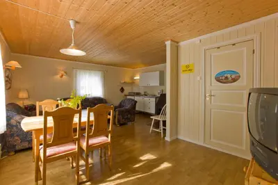 a dining room and living room with a table and chairs at Magalaupe Camping in Oppdal