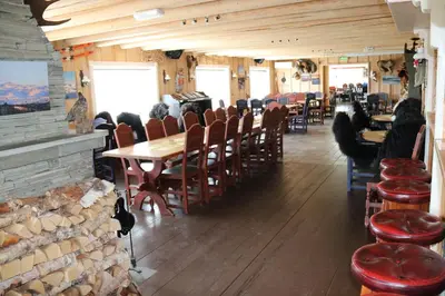 a restaurant with wooden floors and tables and chairs at Gamlestølen Fjellstue in Etnedal