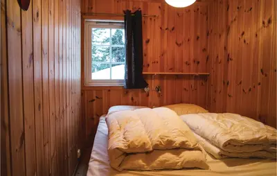 two beds in a room with a window at Sjusjøen Pihl 4020 in Sjusjøen