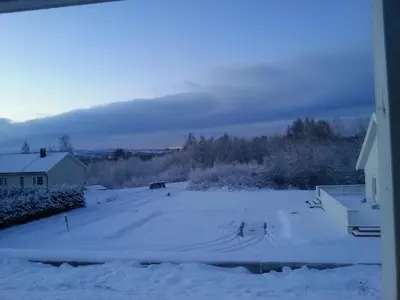 a snow covered yard with a car in the distance at Kylstad Bed and Breakfast in Kylstad