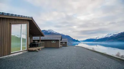 a house with a view of a lake and mountains at Lofthus Camping in Lofthus