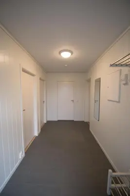an empty hallway with white walls and white doors at Lofthus Camping in Lofthus