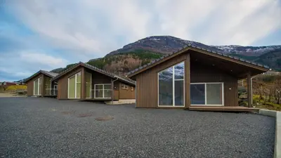 a row of cottages in front of a mountain at Lofthus Camping in Lofthus