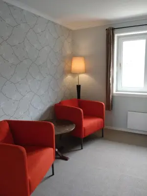 a waiting room with two chairs and a table and a window at Hardanger Rom & Harmonium 