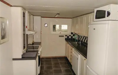 a kitchen with a white refrigerator and a sink at 2 Bedroom Awesome Home In Tørvikbygd in Tyrvikbygd