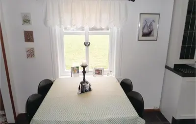 a dining room table with a candle and a window at 2 Bedroom Awesome Home In Tørvikbygd in Tyrvikbygd