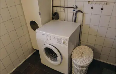 a washing machine in a bathroom with a basket at 2 Bedroom Awesome Home In Tørvikbygd in Tyrvikbygd
