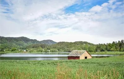 a small cabin in a field next to a lake at 2 Bedroom Awesome Home In Tørvikbygd in Tyrvikbygd