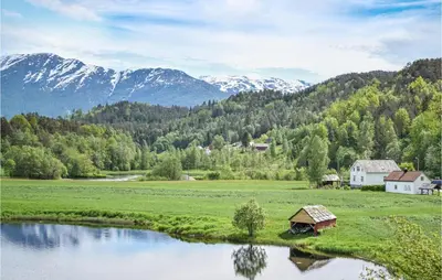 a small house in a field next to a river at 2 Bedroom Awesome Home In Tørvikbygd in Tyrvikbygd