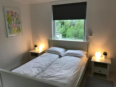 a bed in a room with a window and two lights at Vinstra Hostel in Vinstra