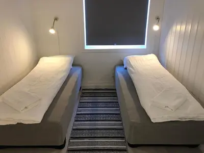 two beds in a small room with a window at Vinstra Hostel in Vinstra