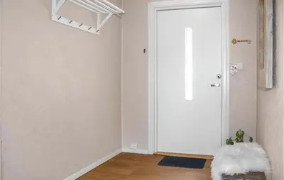a white door in a room with a wooden floor at Three-Bedroom Holiday Home In Vikanes in Eiknes