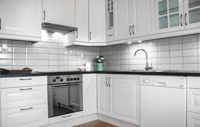 a white kitchen with white cabinets and a sink at Three-Bedroom Holiday Home In Vikanes in Eiknes