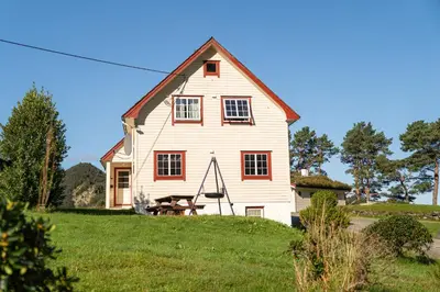 a white house with a picnic table in front of it at Skottneset Feriesenter in Barmen