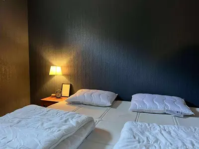 two white beds in a room with a wall at Fonnagata in Åndalsnes