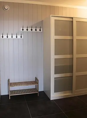 a room with a bench and a wall with shelves at City View Studio Apartment in Ålesund