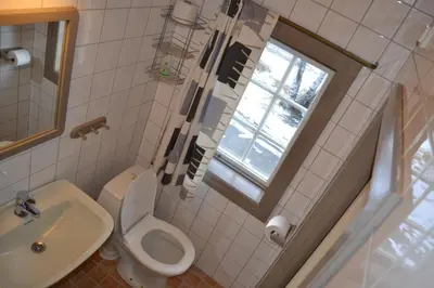 a bathroom with a toilet and a sink and a window at Vekve Hyttetun in Oppdal