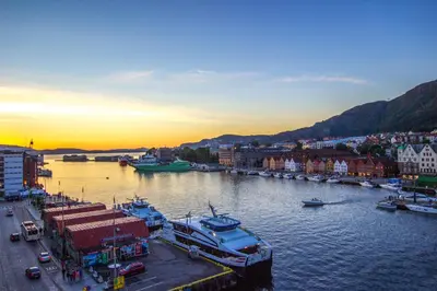 a harbor with boats in the water at sunset at Magic Kloverhuset Harbour Hotel, a member of Radisson Individuals in Bergen