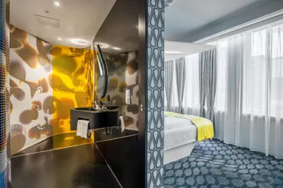 a hotel room with a bathroom with a bed and a sink at Magic Hotel Bergen City Center, a member of Radisson Individuals in Bergen