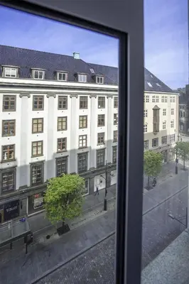 a view of a large white building from a window at Prize by Radisson, Xhibition Bergen City in Bergen