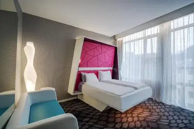 a bedroom with a bed with a pink headboard at Prize by Radisson, Xhibition Bergen City in Bergen
