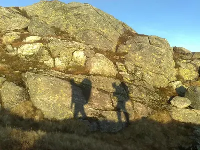 two shadows of two people on a rock wall at Rongen gard in Bolstadøyri