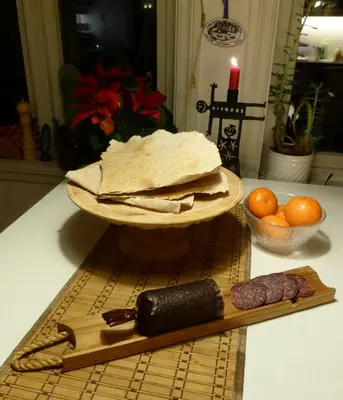 a table with a plate of tortillas and a cutting board at Rongen gard in Bolstadøyri