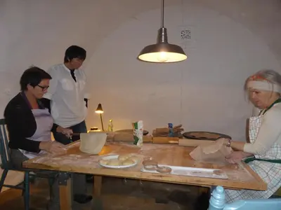 a group of people in a kitchen preparing food at Rongen gard in Bolstadøyri