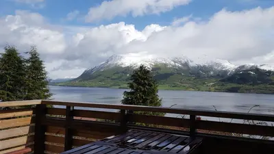 a view of a snow covered mountain with a bench at Holiday Home Kvernesfjorden in Averoy