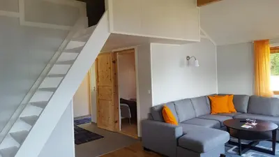 a living room with a blue couch and a staircase at Holiday Home Kvernesfjorden in Averoy
