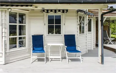 two blue chairs and a table on a porch at Gorgeous Home In Førde I Hordaland in Førde