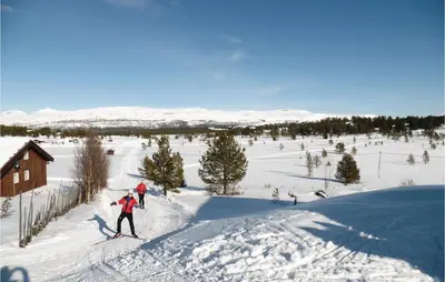 two people are skiing down a snow covered slope at Amazing Home In Kvam With Kitchen in Kvam