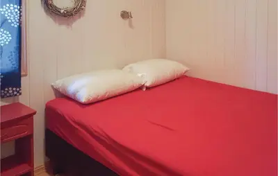 a bed with two pillows on it in a room at Amazing Home In Kvam With Kitchen in Kvam