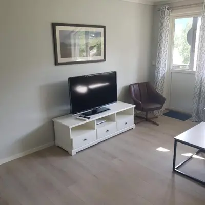 a living room with a flat screen tv on a white cabinet at Mørkve Apartement in Myrkdalen