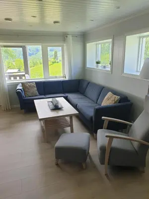 a living room with a blue couch and a table at Mørkve Apartement in Myrkdalen