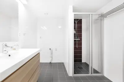 a white bathroom with a shower and a sink at Namsos Hybelhus in Namsos