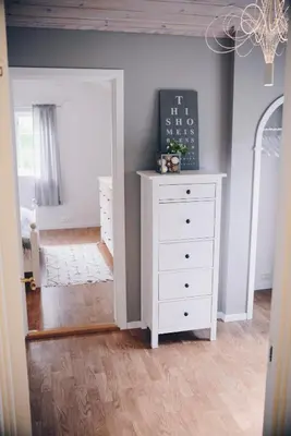 a room with a white dresser and a bedroom at Dalhus - House with jacuzzi in Norddal