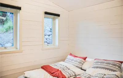 a bed in a room with two windows at Nice Home In Ornes With House Sea View in Ornes