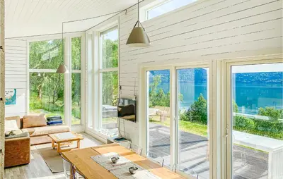 a living room with large windows and a view of the water at Nice Home In Ornes With House Sea View in Ornes