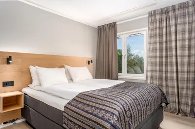 a bedroom with a bed and a window at Birkebeineren Hotel & Apartments in Lillehammer