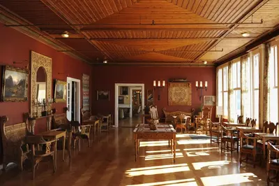 a room with tables and chairs in a room with red walls at Kviknes Hotel in Balestrand