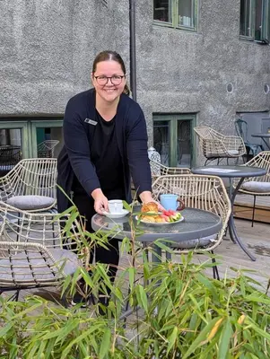 a woman sitting at a table with a plate of food at Hotel Breiseth in Lillehammer