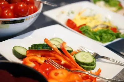 a plate of vegetables on a table with forks at Hotel Breiseth in Lillehammer