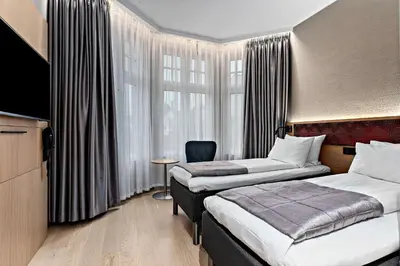 a hotel room with two beds and a television at Bergen Harbour Hotel, WorldHotels Crafted in Bergen