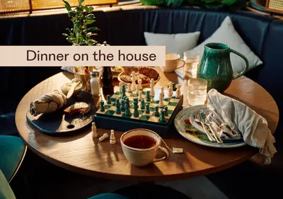 a wooden table with a chess board and dishes of food at Home Hotel Hammer in Lillehammer