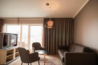 a living room with a couch and a tv at Home Hotel Hammer in Lillehammer