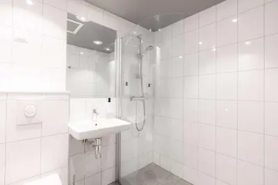 a white bathroom with a sink and a shower at Scandic Valdres in Fagernes