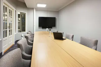 a conference room with a long table with a laptop on it at Scandic Valdres in Fagernes