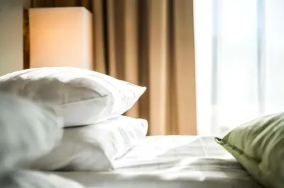 a bed with white pillows and a window at Scandic Valdres in Fagernes
